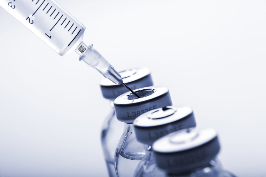 Glass medicine vials and Syringe on white background
