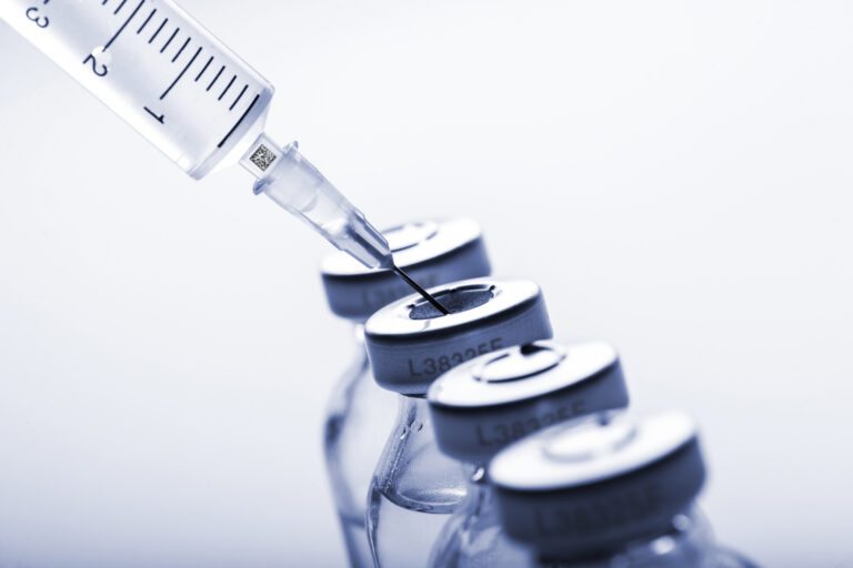 Glass medicine vials and Syringe on white background